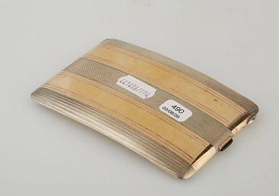 a silver and gold cigarette case on a white table