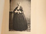 an old picture of a woman in a black dress
