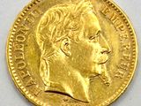 a close up of a gold coin on a white surface