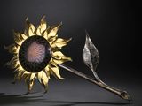 an image of a metal sunflower with a stem and a leaf