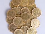 a pile of gold coins sitting on a white surface