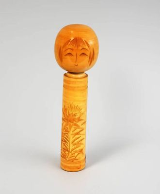figurine en bois représentant une femme avec un tournesol sur la tête