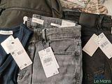 three pairs of men ' s jeans with price tags on them