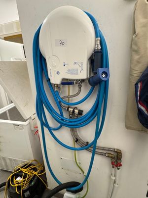 un tuyau bleu fixé à un mur blanc, à côté d'un autre tuyau bleu