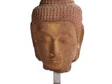 statue représentant une tête de Bouddha posée sur un socle en bois