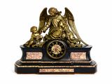 une statue représentant un ange tenant un enfant sur une horloge