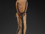 a wooden headdress with long hair on a black stand