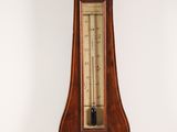 a large wooden clock with a barometer on top of it