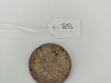 a close up of a coin on a white surface with a tag