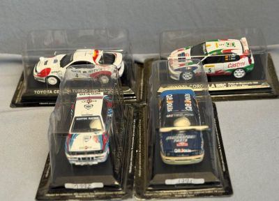 trois modèles réduits de voitures sont exposés dans une vitrine posée sur une table