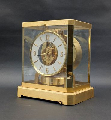 a gold clock that is sitting in a glass case
