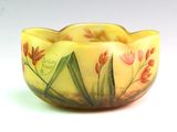 un bol jaune sur lequel sont peintes des fleurs rouges