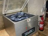 une photo d'un congélateur coffre en acier inoxydable posé sur une table en bois