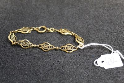 a close up of a gold bracelet with a tag on it