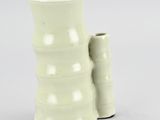 two white vases sitting next to each other on a white surface