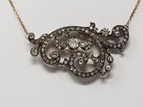 un collier en or et diamants posé sur un fond blanc