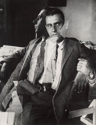 black and white photograph of a man in a suit sitting in a chair