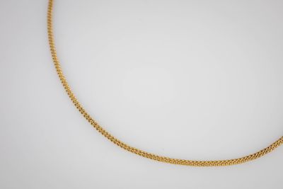 un collier à chaîne en or sur fond blanc