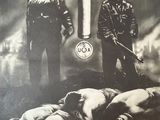 an old poster of two soldiers standing next to a man laying on the ground