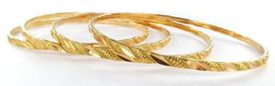 three gold rings on a white surface with a white background