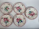 quatre assiettes ornées de fleurs sont posées sur une table