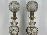 une paire de vases ornés d'oiseaux et de fleurs sur fond blanc