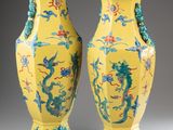 pair of yellow vases with blue and red designs on them