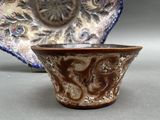 a brown bowl and a blue and white bowl on a table