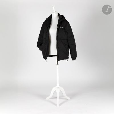 une veste noire posée sur un mannequin, sur fond blanc