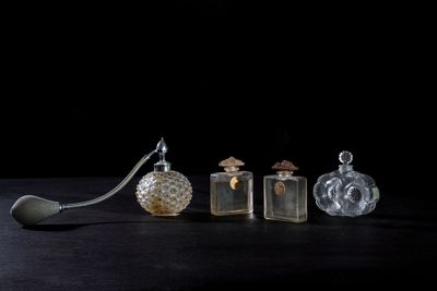 three glass bottles and a spoon sitting on a table