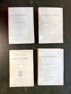 four old books on a table with a black background
