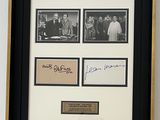 une image représentant une photo encadrée d'un groupe de personnes, sur laquelle figurent des autographes