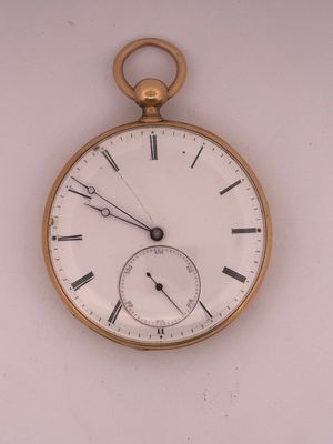a gold pocket watch with roman numerals on the face