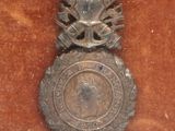 a silver medal with a crown on top of it