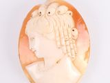 an antique carved shell cameo of a woman with flowers in her hair