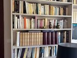 une lampe posée sur une table devant une bibliothèque