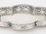 une assiette ancienne en argent, ornée d'un motif décoratif sur le bord