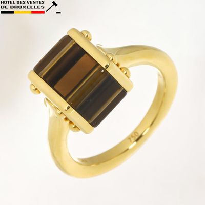 une image représentant une bague en or sertie d'une pierre brune