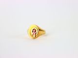 un gros plan d'une bague en or ornée d'un ruban rose