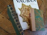 a book on the floor next to a pair of old books