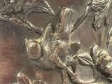 un gros plan d'une plaque métallique sur laquelle figure un oiseau