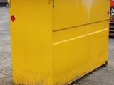 a yellow dumpster sitting in a parking lot next to other trucks
