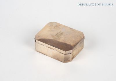 une boîte argentée posée sur une surface blanche, avec un fond blanc