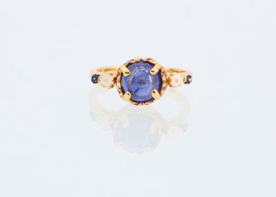 Gros plan sur une bague en or ornée d'un saphir bleu