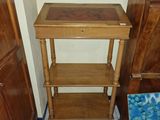 une petite table surmontée d'une étagère, dans une pièce