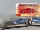 three toy cars are sitting in a display case on a table