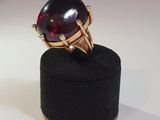 a black ring with a red stone on top of a black box