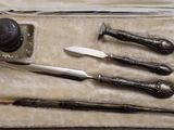 un étui contenant un couteau, un aiguiseur de couteaux et d'autres objets