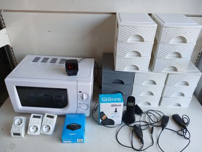a white microwave sitting on a table next to a stack of boxes