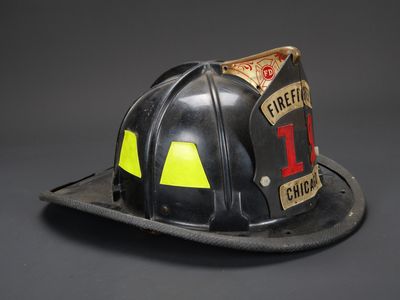 casque de pompier sur fond gris, orné d'autocollants jaunes et rouges